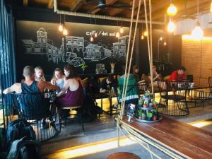 a group of people sitting at tables in a restaurant at Phuket Sunny Hostel in Phuket Town