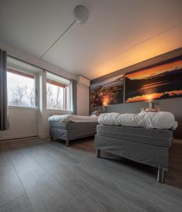 a bedroom with two beds and a painting on the wall at Abisko Hostel in Abisko