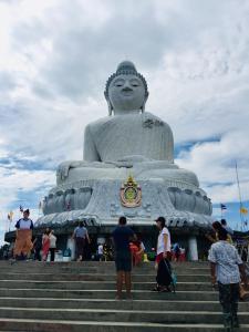 people standing around a large statue on the stairs at Phuket Sunny Hostel in Phuket Town