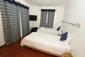 Dos camas en una habitación con dos ventanas. en Casa Antonio, en Armação de Pêra 23 fotos más