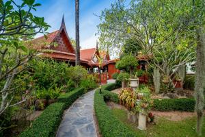 Royal Thai Villa Phuket - SHA Extra Plus في شاطئ راوايْ: حديقة امام المنزل