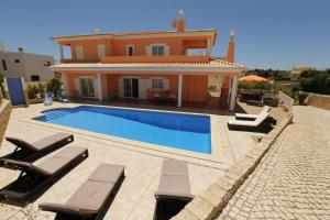 una villa con piscina frente a una casa en Casa Antonio, en Armação de Pêra