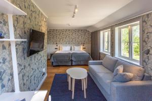 Habitación de hotel con cama y sofá en Lindesbergs Hotell en Lindesberg