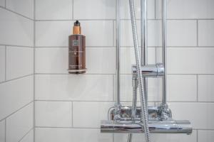 um chuveiro com um dispensador de sabão na casa de banho em Lindesbergs Hotell em Lindesberg