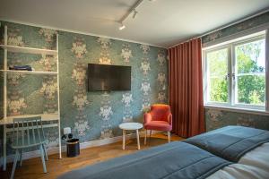 a bedroom with a bed and a tv on the wall at Lindesbergs Hotell in Lindesberg