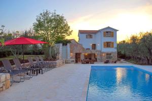 eine Villa mit einem Pool vor einem Haus in der Unterkunft Villa Nadia in Dobrinj