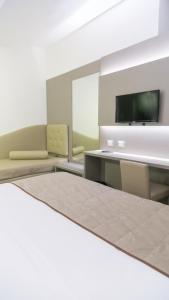 um quarto com uma mesa e cadeiras e uma televisão em Hotel Principe em Módena