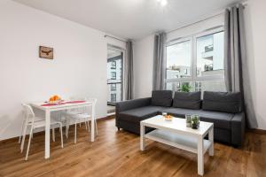 a living room with a couch and a table at Waw - Apartamenty Wilanów I in Warsaw