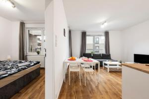 a bedroom and a living room with a bed and a table at Waw - Apartamenty Wilanów I in Warsaw