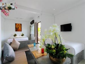 ein Wohnzimmer mit einem Bett und einem Tisch mit Blumen in der Unterkunft Samui Beach Residence Hotel in Chaweng