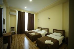 a hotel room with two beds and a television at Hotel Comfort in Kutaisi