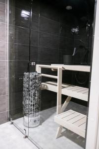 a bathroom with a shower with a bench next to a shower at Santasport Apartment Hotel in Rovaniemi