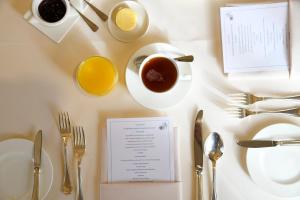 a table with a cup of tea and a plate of food at Whatley Manor in Malmesbury