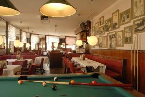 a pool table in a restaurant with tables and chairs at Madar Café Central Melk in Melk
