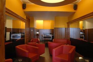 comedor con sillas rojas y cocina en Madar Café Central Melk, en Melk