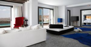 - un salon avec deux canapés blancs et une chaise rouge dans l'établissement Myconian Avaton, a Member of Design Hotels, à Plage d'Élia
