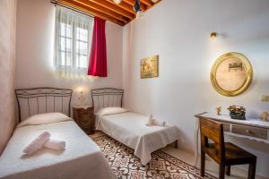 1 dormitorio con 2 camas, tocador y espejo en Villa Amalia, en Lindos