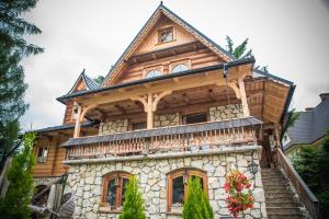 a large wooden house with a steep roof at Rezydencja Sąsiadów Zakopanego in Zakopane