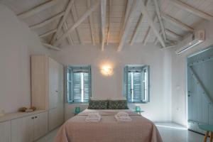 a white room with a bed with towels on it at moonhouse in Skiathos