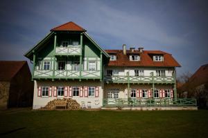 ein großes grünes und weißes Haus mit rotem Dach in der Unterkunft Seehotel Huberhof in Seehausen