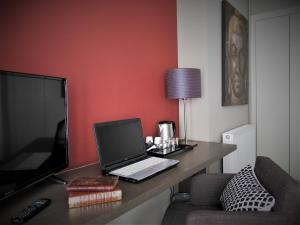a laptop computer sitting on a desk in a room at Be Cottage Hotel in Le Touquet-Paris-Plage