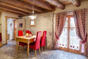 a dining room with a wooden table and red chairs at Chalet Sogno di Fiaba in Nembia
