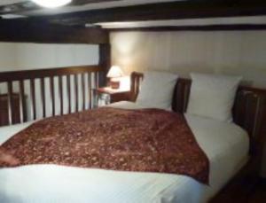 a bedroom with a large bed with white sheets and pillows at Les Remparts de Bergheim in Bergheim