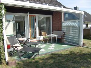 un porche cubierto con sillas y mesa en Ferien Haus Pelle, en Pelzerhaken