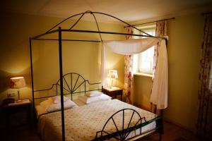 ein Schlafzimmer mit einem Metall-Himmelbett und weißen Kissen in der Unterkunft Seehotel Huberhof in Seehausen