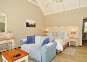 a bedroom with a bed and a couch and a table at The Gables Hermanus in Hermanus