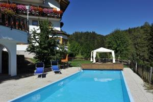 einen Pool mit zwei Stühlen und einem Pavillon in der Unterkunft Hotel Langeshof in Anterivo