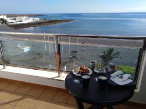 - une table avec des boissons et une vue sur l'océan dans l'établissement Ocean Front Apartment (WiFi), à Tetir