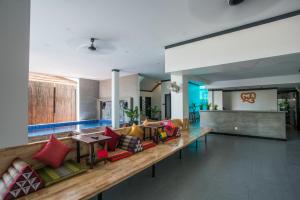 a lobby with a long couch with colorful pillows at Noni Tree Hostel in Siem Reap
