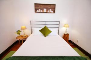 ポンタ・ド・パールゴにあるCasa Beneditaのベッドルーム(大きな白いベッド1台、ランプ2つ付)