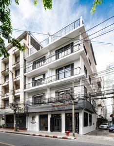 a white building on the corner of a street at Warm Window Silom in Bangkok