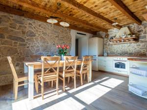 een keuken met een houten tafel en stoelen en een stenen muur bij Gorgeous villa in Malinska with private pool in Malinska