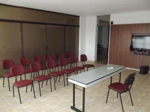 a conference room with red chairs and a table at L'Hirondelle Flat Service in Campinas