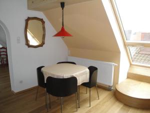 een eetkamer met een tafel en stoelen en een spiegel bij Bed & Kitchen Burgau in Burgau