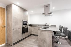 una cocina con encimera y algunas sillas. en Casa Fresa - Castlehill Apartment en Dundee