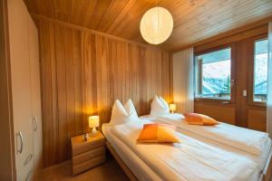 a bedroom with a bed with white sheets and orange pillows at Casa Serena in Arosa