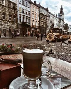 リヴィウにあるViP apartment in ♥ of Lvivの通りの前のテーブルに座ってコーヒーを飲む
