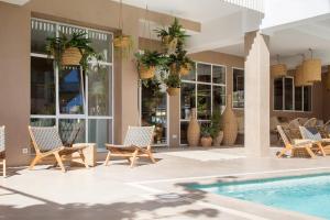 a patio with chairs and a swimming pool at The 15th Boutique Hotel in Lloret de Mar