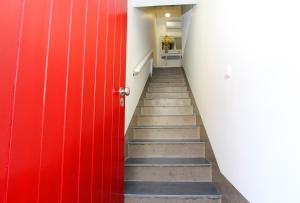 a stairway with a red door and a red wall at Casa do Tablado - Foz Côa in Vila Nova de Foz Coa