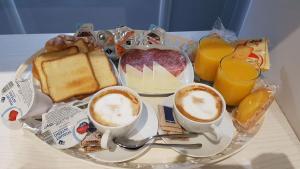 einen Teller mit Frühstückslebensmitteln und Getränken auf dem Tisch in der Unterkunft Il Corso Suite in Rom