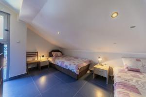Un dormitorio con dos camas y dos mesas con lámparas. en Villa Tivat, en Tivat 46 fotos más