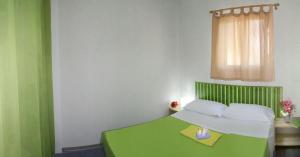 a bedroom with a green and white bed and a window at Camping Villaggio Lamaforca in Torre Santa Sabina +27 photos