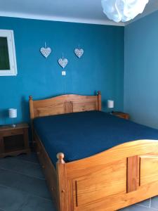 um quarto com uma cama de madeira e uma parede azul em Villa La Marpierre em Mondragon