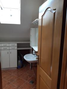 a bathroom with a sink and a toilet and a door at Apartman Kupres Centar in Kupres
