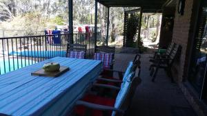 un tavolo blu e sedie su un patio di Gowrie Agapanthus a Singleton