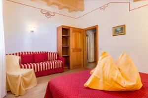 sala de estar con sofá y cama roja en Casa Nonni en Molveno